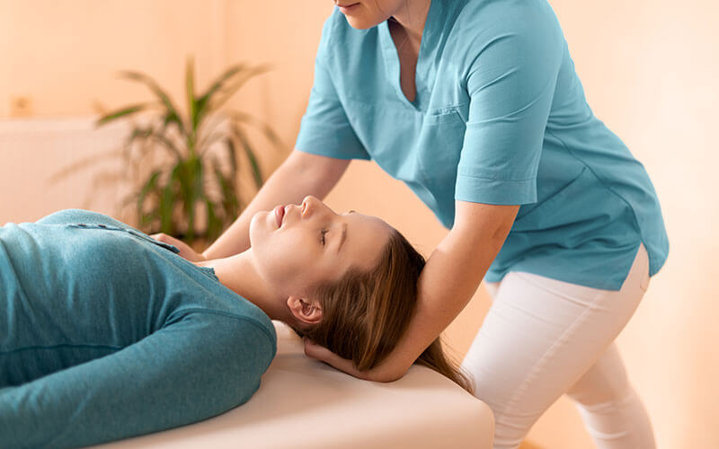 Physiotherapy staff member provides rehabilitation and chiropractic adjustment to young female patient at Advantage Integrated Health